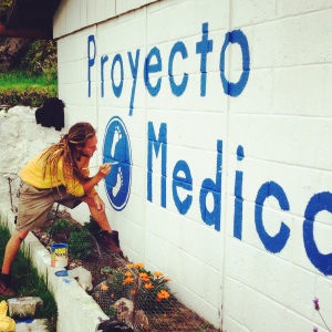 Local volunteer painting a new sign outside the clinic