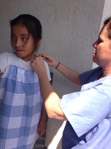 Dr. Lebo dressing one of the children in dresses she brought from home made from pillow cases